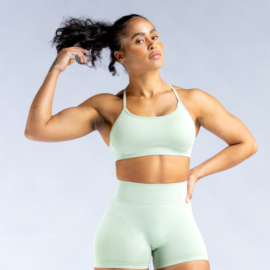 Mint green sports bra with open-back crisscross straps and supportive racerback fit