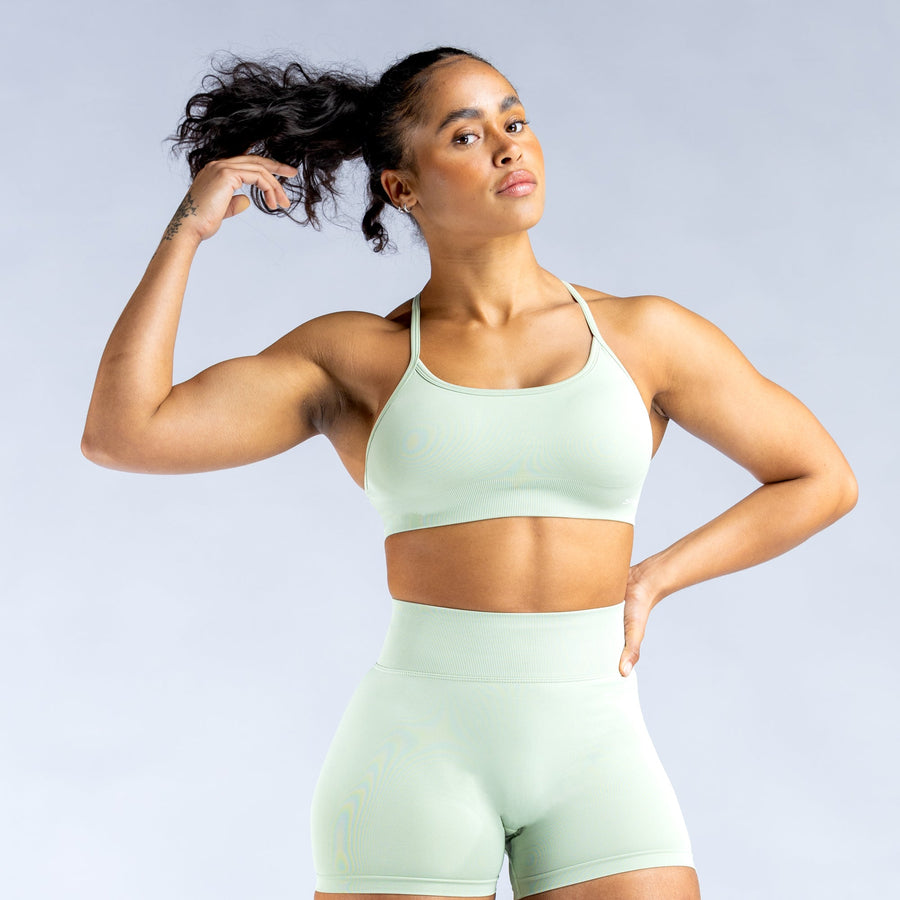 Mint green sports bra with open-back crisscross straps and supportive racerback fit