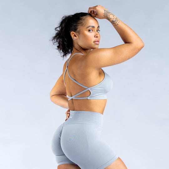 Light blue backless sports bra showing crisscross back straps and wide band