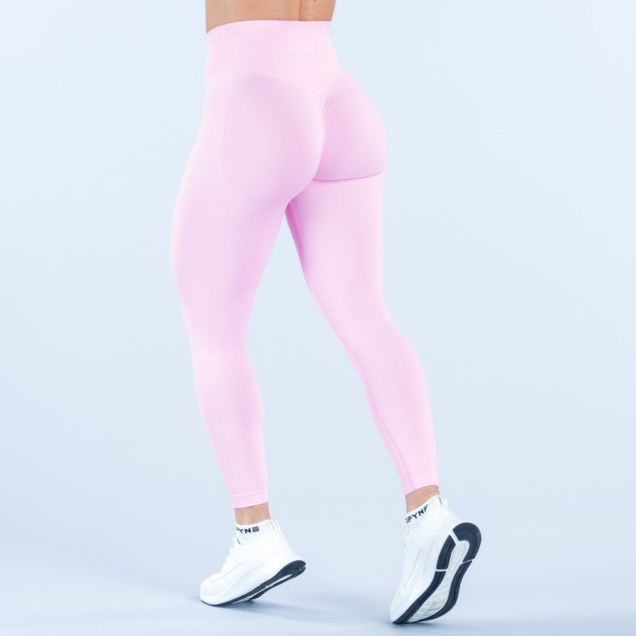 Light pink high-waist leggings with back curve detail, three-quarter view