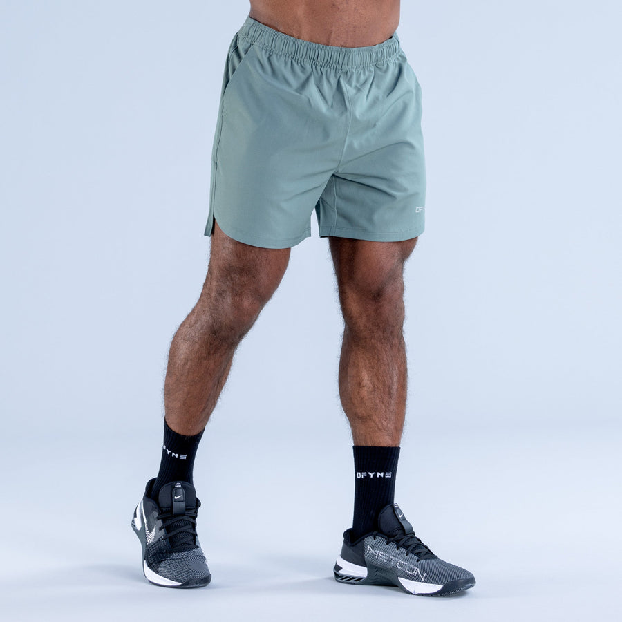 Teal training shorts with elastic waistband and small side logo detail