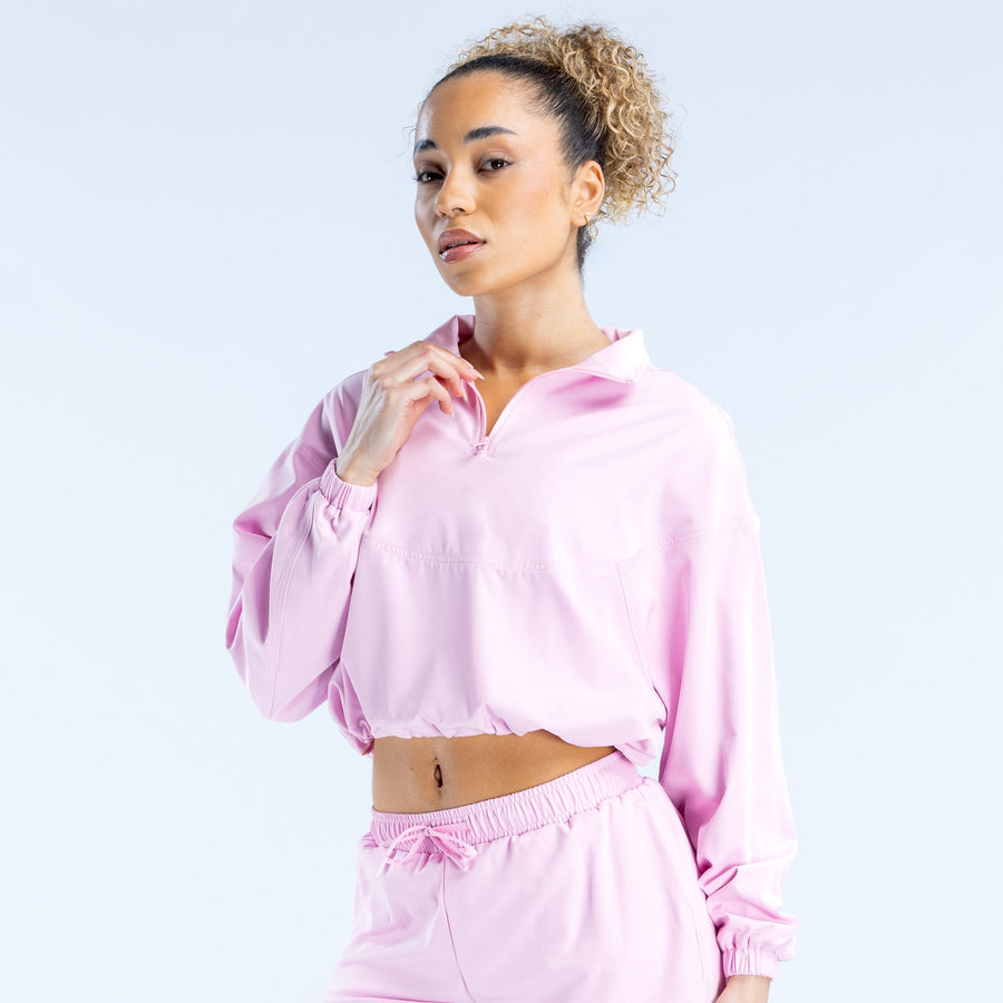 Pink cropped zip jacket front view with half-zip, elastic cuffs, and drawstring hem