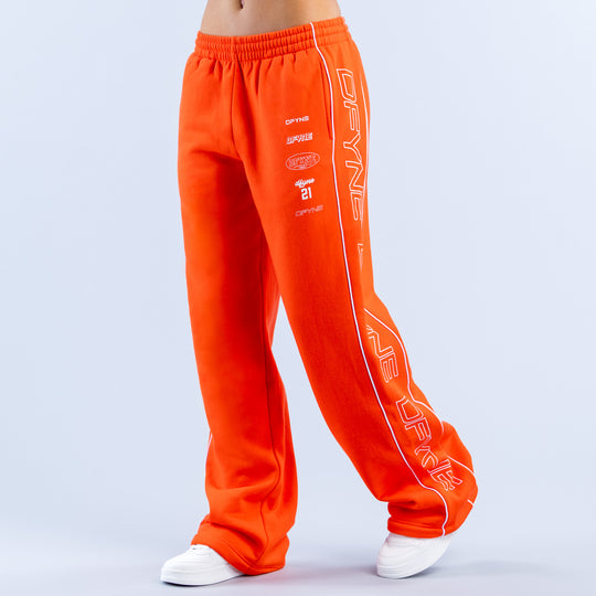 Orange wide-leg joggers with printed side stripe and elastic waistband, straight legs
