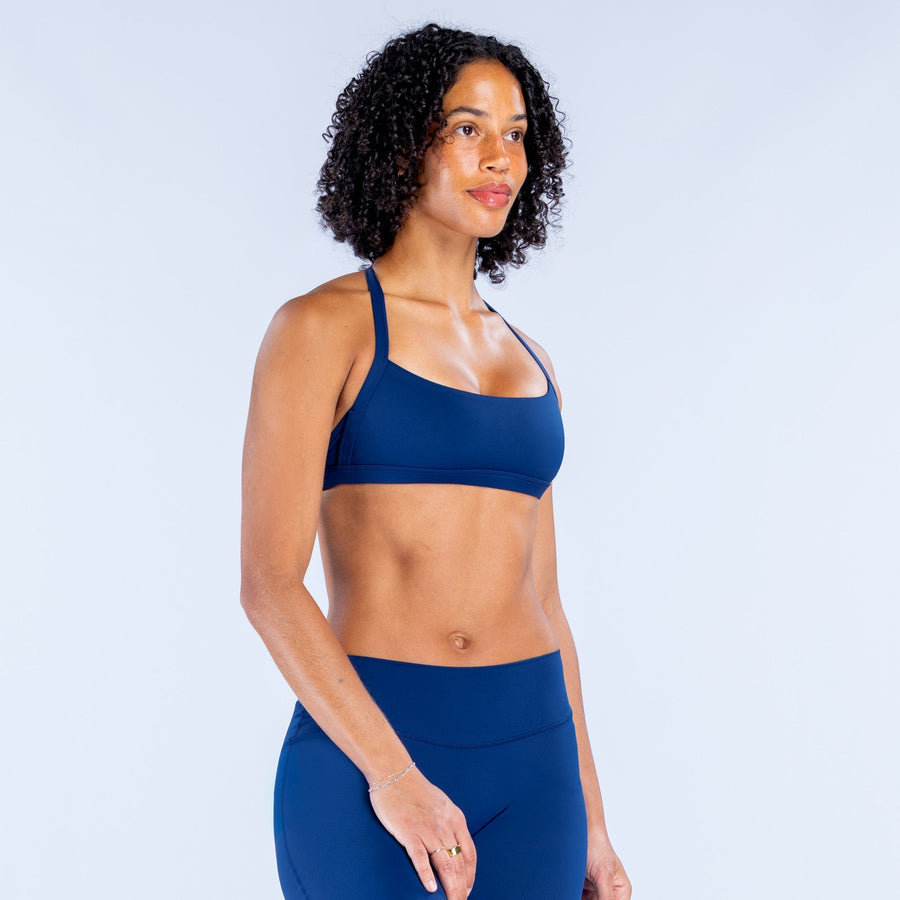 Blue strappy sports bra with wide band and smooth cups.