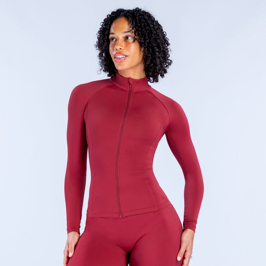 Women’s red zip-up hooded athletic top, close front view with long sleeves