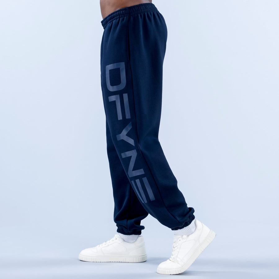 Navy cuffed jogger pants with elastic waistband, side graphic print, and cuffed ankles