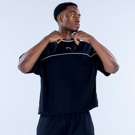 Black jersey with white curved chest panel and crew-neck trim; standing close-up