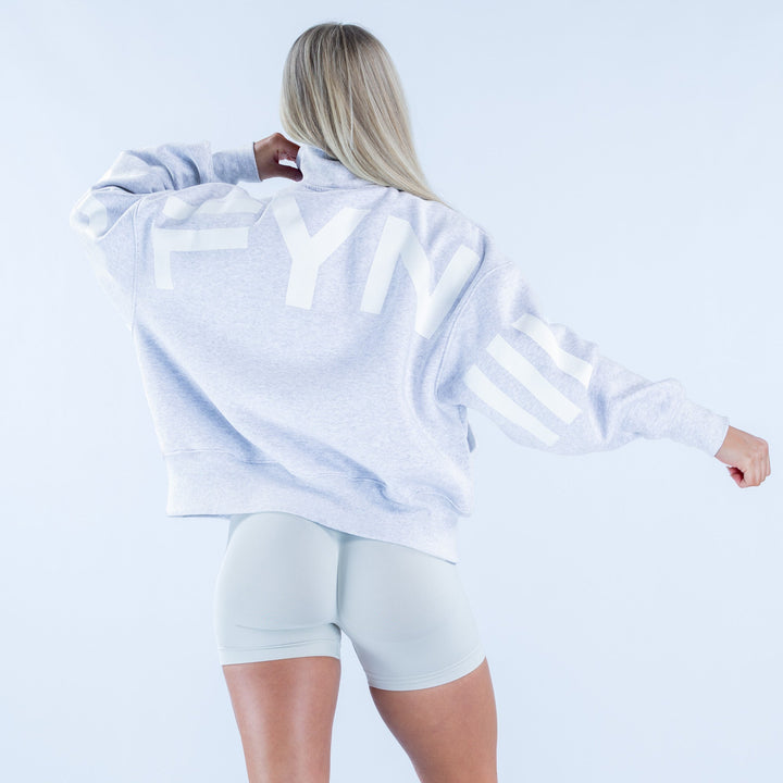 Light gray quarter-zip sweatshirt, back view with full sleeves and hem