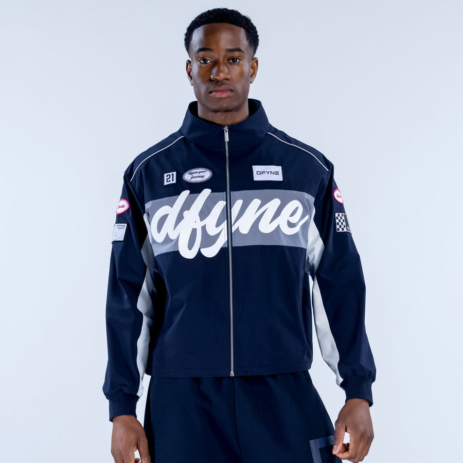 Men's navy track jacket with large white script logo, stand collar, zip front