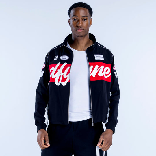 Black track jacket with stand collar and zip front, red chest band, sleeve logo patches