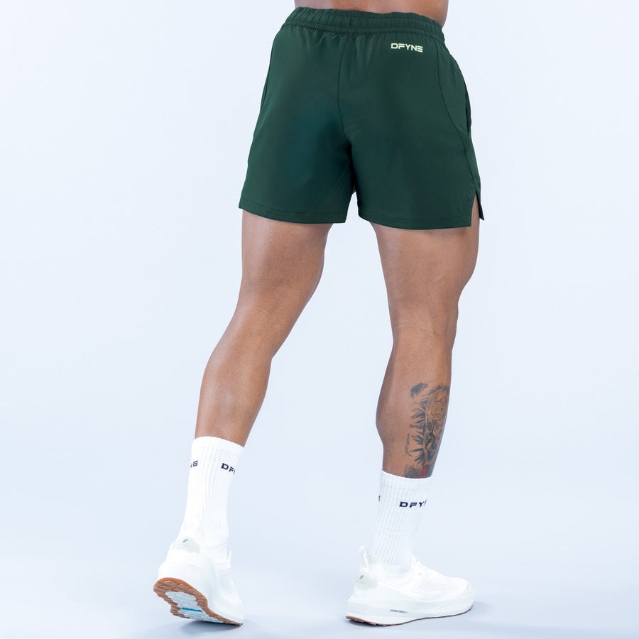 Green training shorts, small logo on back, knee-length with side vents